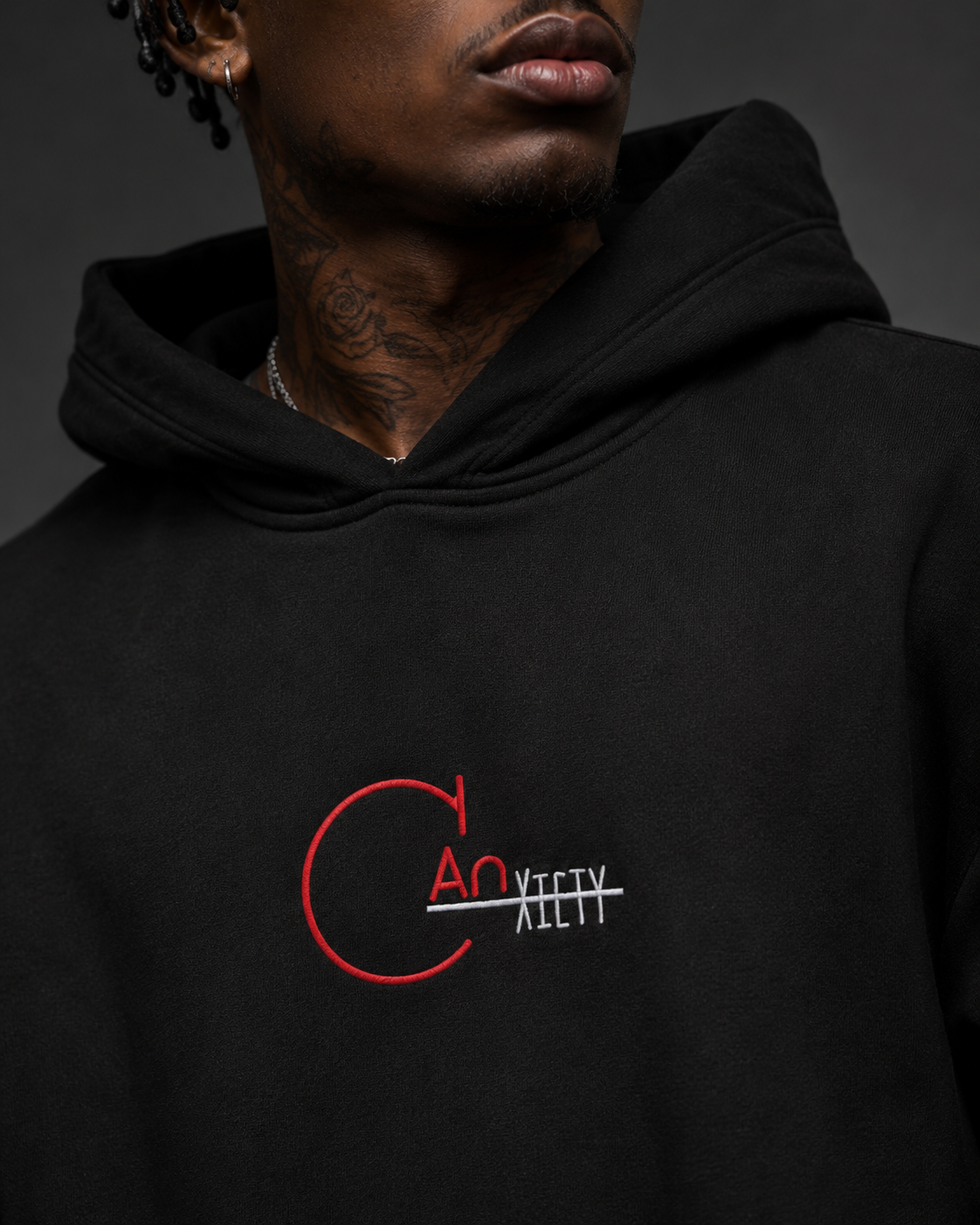 Close-up detail of CANxiety logo embroidery on a black heavyweight hoodie